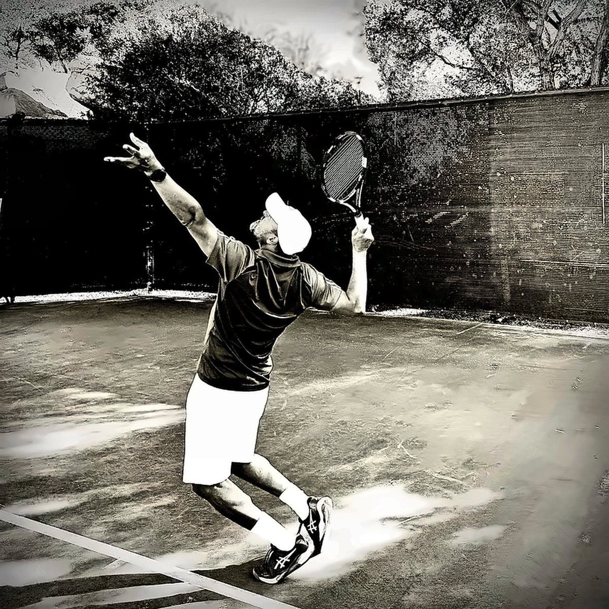 Fawz hitting a serve, black and white